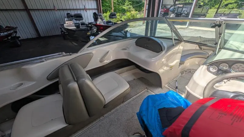 Slide: The Image of 2005 Sea Ray 180 Sport boat interior with seating and dashboard in a storage area. - 9