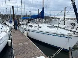 Slide: The Image of 1996 Catalina C-320 sailboat docked at a marina with blue sail cover. - 3