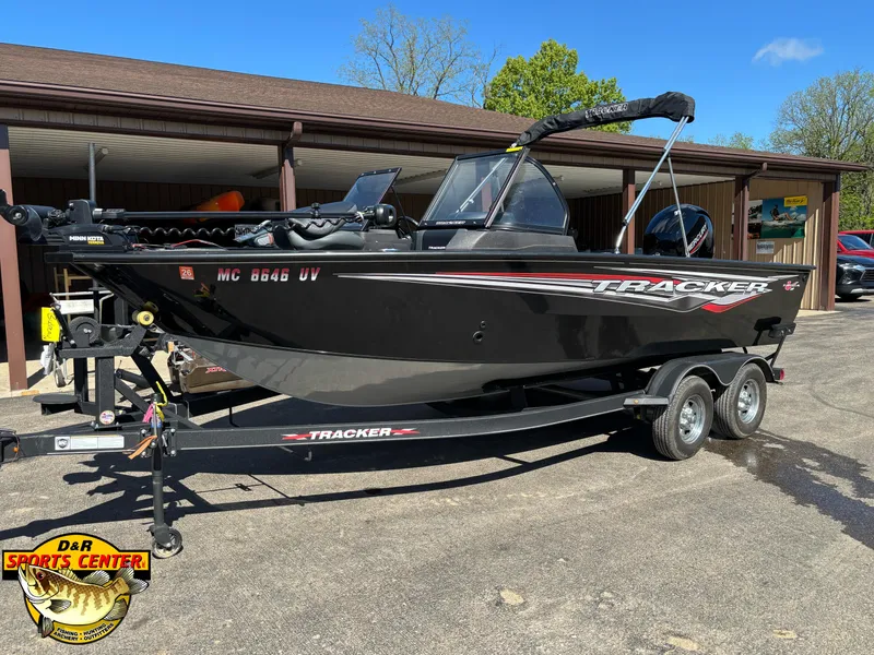 Slide: The Image of 2023 Tracker Targa V-18 Combo boat on trailer, parked outdoors at dealership. - 2
