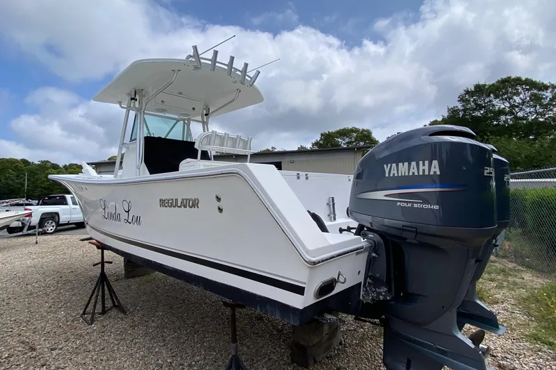 Slide: The Image of 2007 Regulator 29 Forward Seating boat with Yamaha engine, parked outdoors. - 2