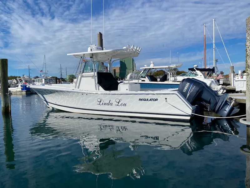 Slide: The Image of 2007 Regulator 29 Forward Seating boat docked in marina, clear sky reflection. - 7