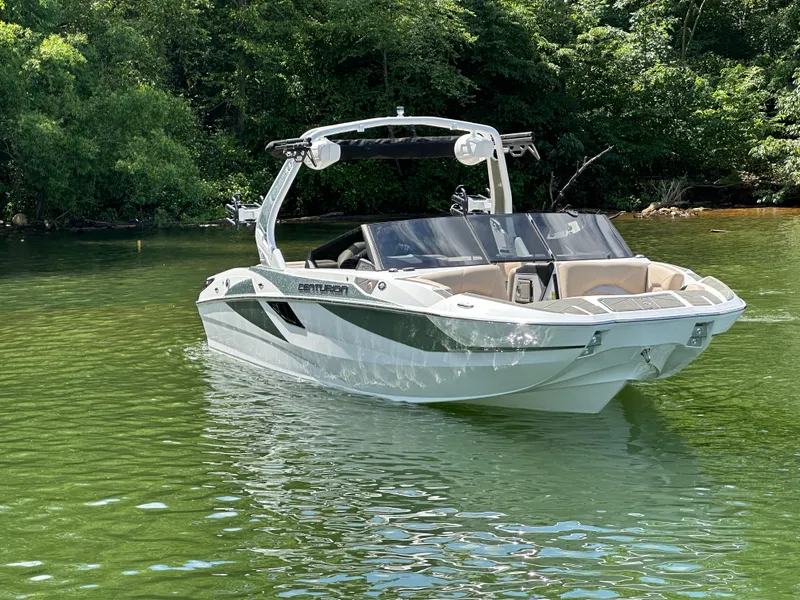 Slide: The Image of 2025 Centurion Fe23 boat on a serene lake, surrounded by lush greenery. - 3