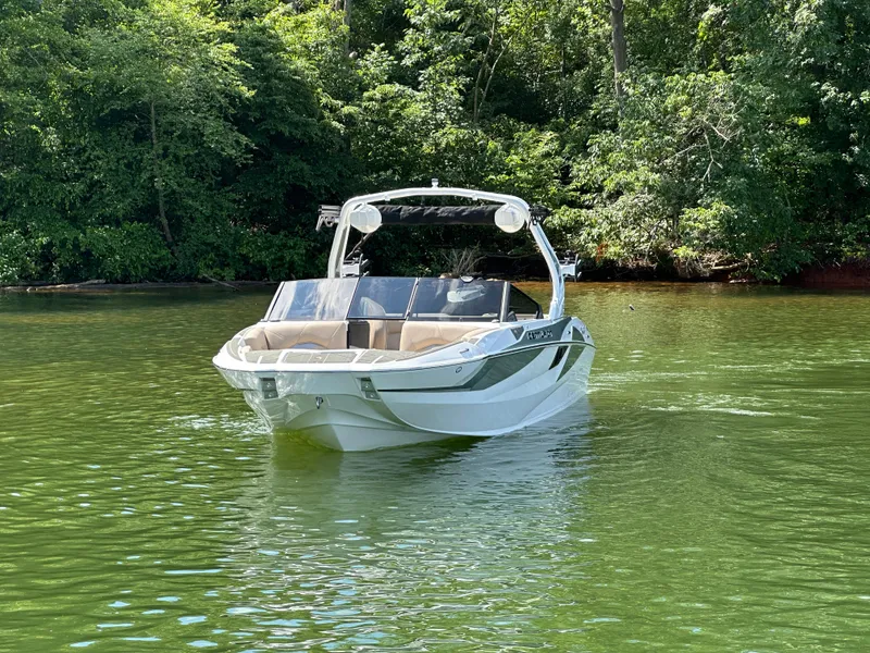 Slide: The Image of 2025 Centurion Fe23 boat on a serene green lake, surrounded by lush trees. - 4