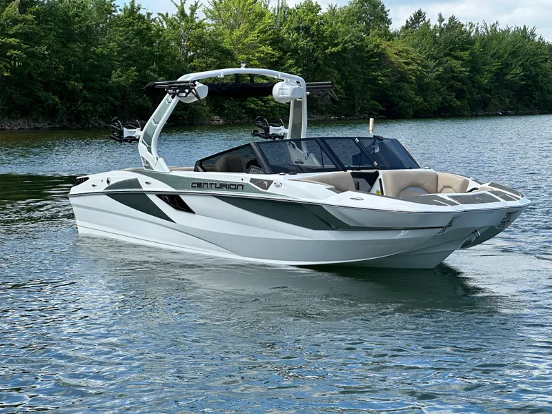 Slide: The Image of 2025 Centurion Fe23 boat on a serene lake with lush green trees. - 5