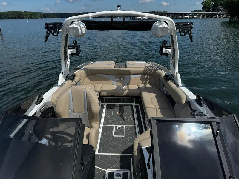 Slide: The Image of 2025 Centurion Fe23 boat interior with beige seating on a calm lake. - 8