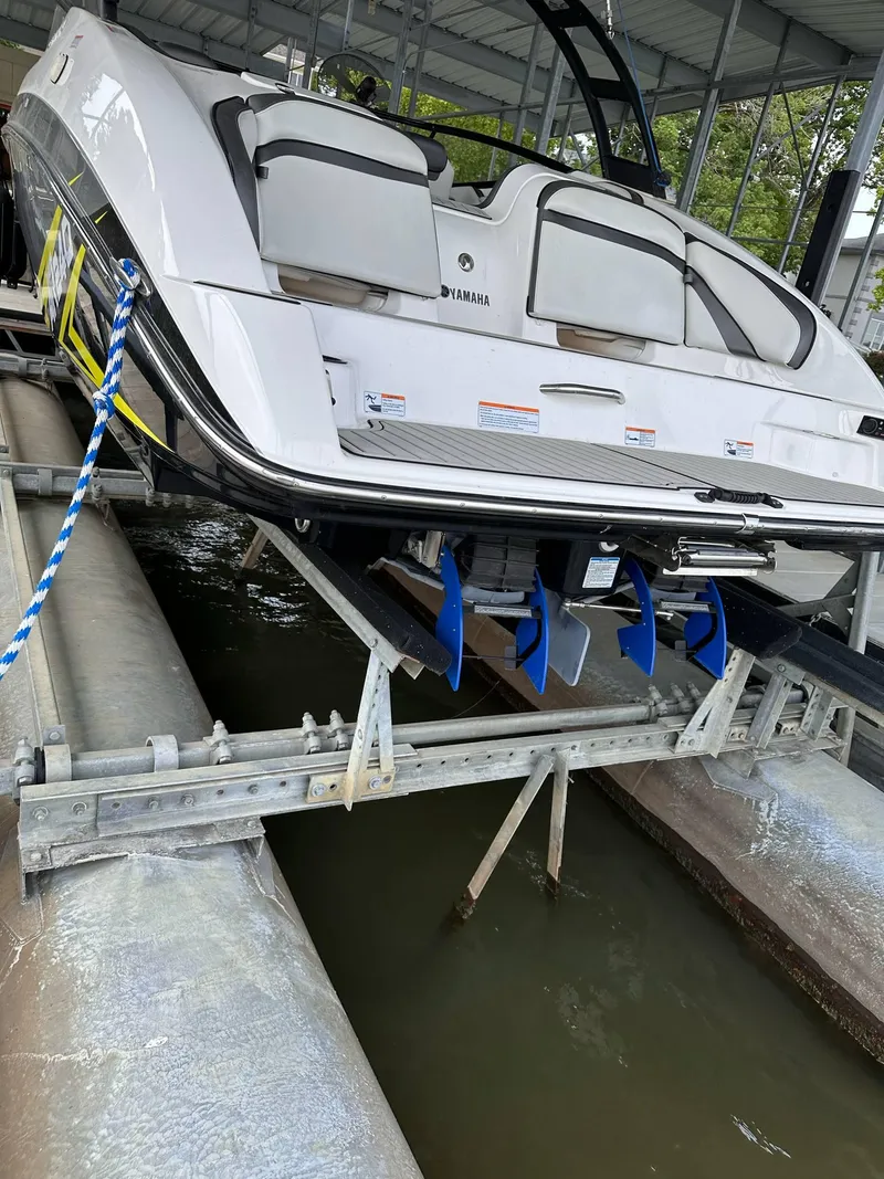 Slide: The Image of 2020 Yamaha AR240 boat on lift, showcasing sleek design and dual engines. - 7