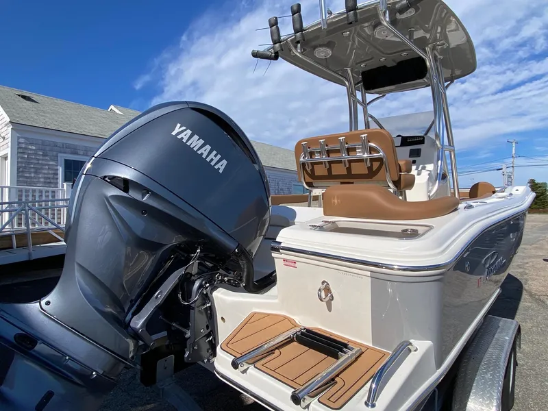 Slide: The Image of 2025 Pioneer 222 Islander boat with Yamaha engine, docked under clear blue sky. - 2