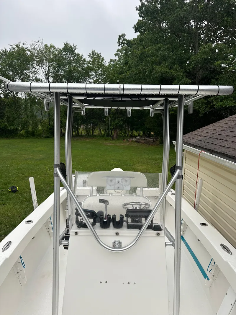 Slide: The Image of 2015 Allied 17 Explorer boat with T-top, parked near trees and a building. - 16