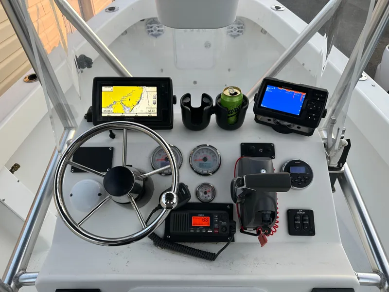 Slide: The Image of Boat dashboard with navigation screens, steering wheel, gauges, and a beverage can. Allied 17 Explorer, 2015. - 18