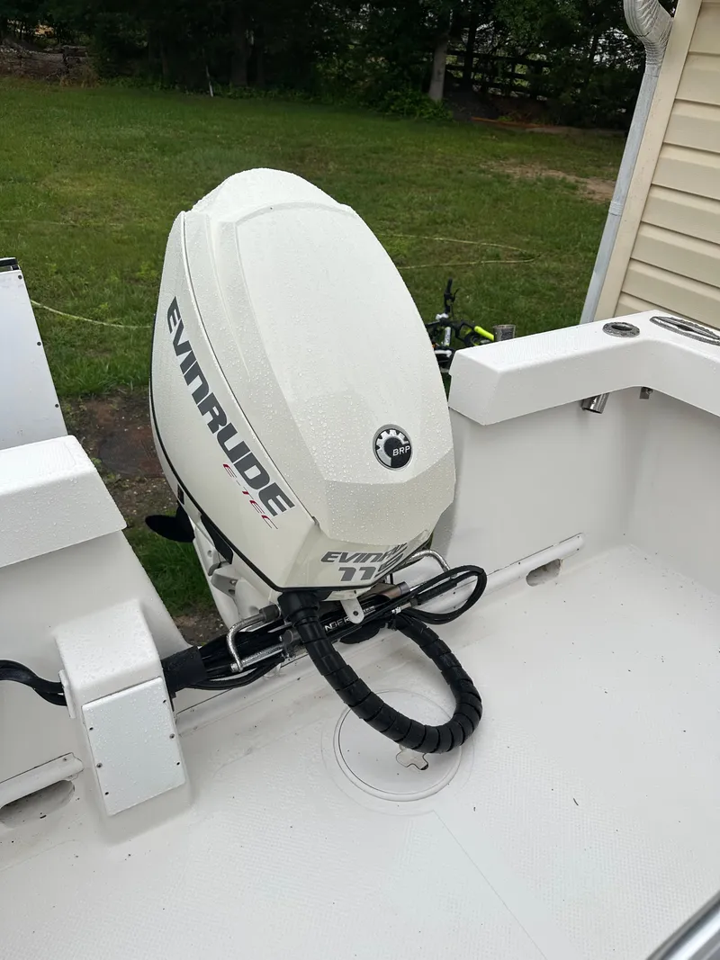 Slide: The Image of 2015 Allied 17 Explorer boat with Evinrude outboard motor, parked outdoors. - 24