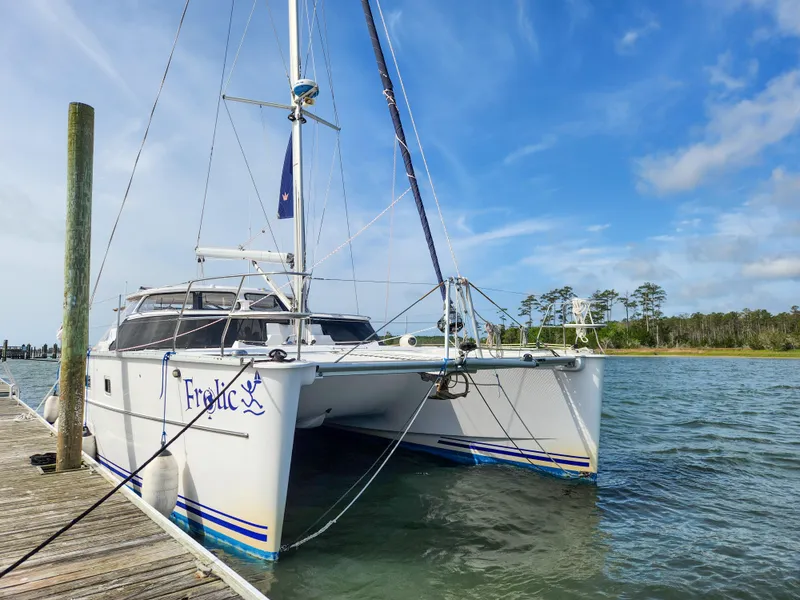 The Image of Sailing catamaran Antares 44i, 2014 model, docked by a wooden pier on a sunny day. - 0