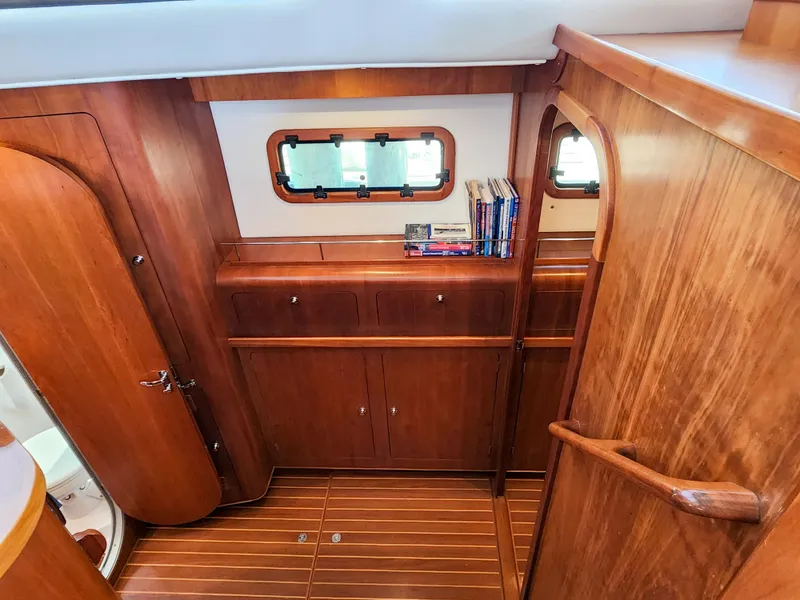 Slide: The Image of Wooden interior of 2014 Antares 44i yacht with books and porthole window. - 10