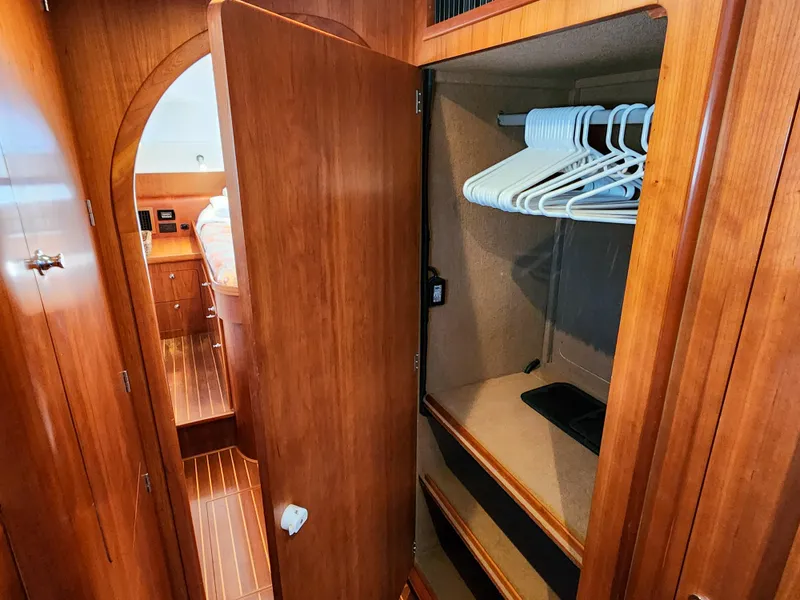 Slide: The Image of Wooden closet interior on 2014 Antares 44i yacht with hangers and shelves. - 12