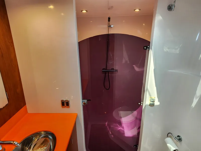 Slide: The Image of Modern bathroom in 2014 Antares 44i yacht with vibrant orange countertop and purple shower. - 13