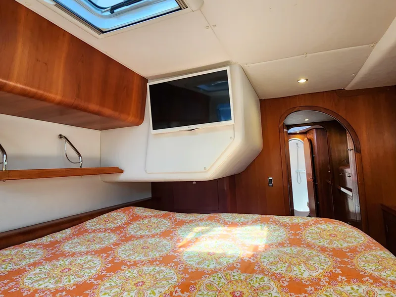 Slide: The Image of Luxurious Antares 44i 2014 yacht cabin with TV, skylight, and vibrant bedding. - 17