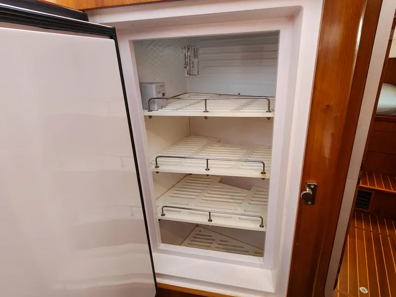 Slide: The Image of Open refrigerator with empty shelves inside a 2014 Antares 44i yacht. - 22