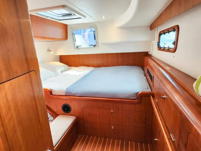 Slide: The Image of Cozy cabin interior of 2014 Antares 44i yacht with wooden furnishings and a comfortable bed. - 24