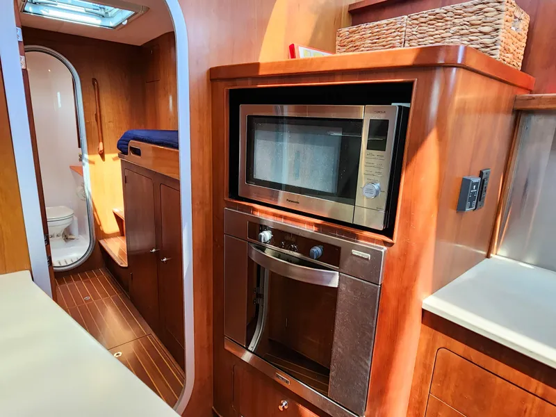 Slide: The Image of 2014 Antares 44i yacht interior with microwave, oven, and wooden cabinetry. - 25