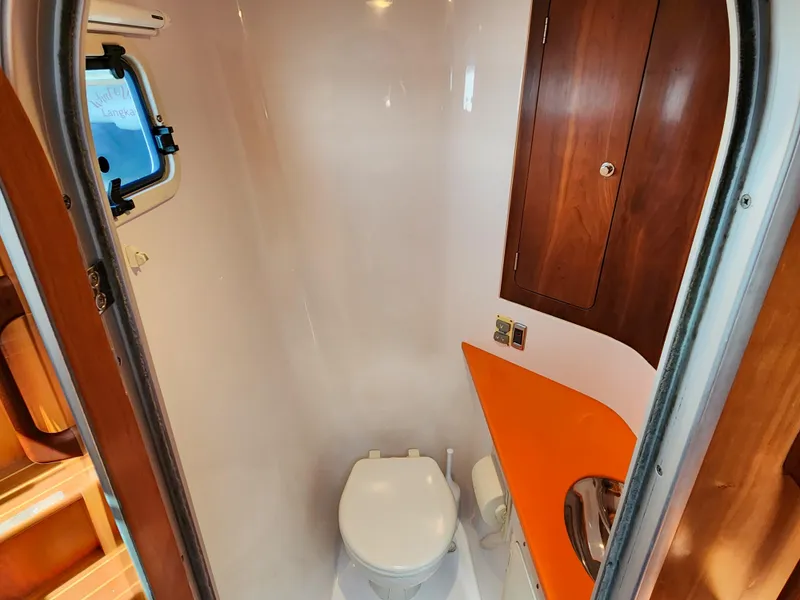 Slide: The Image of Compact bathroom in a 2014 Antares 44i yacht with wooden cabinetry and orange countertop. - 31
