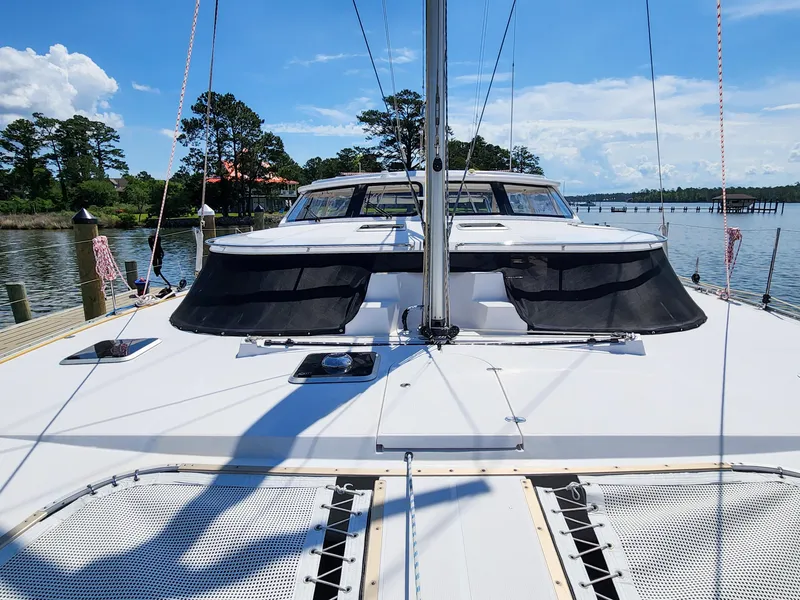 Slide: The Image of Catamaran Antares 44i, 2014 model, docked by a scenic waterfront with clear blue skies. - 33