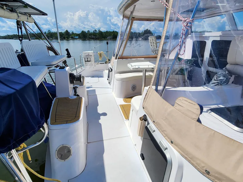 Slide: The Image of 2014 Antares 44i yacht deck with seating, clear canopy, and scenic water view. - 40