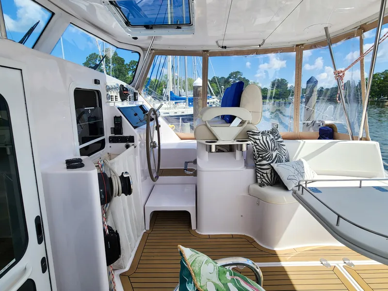 Slide: The Image of Cockpit of 2014 Antares 44i yacht with helm, seating, and marina view. - 44