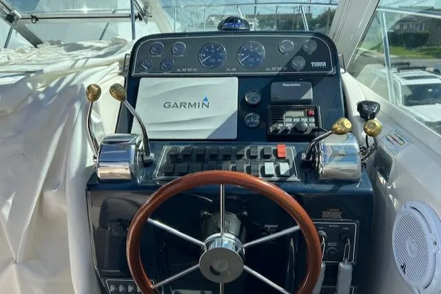 Slide: The Image of 2004 Tiara Yachts 2900 Coronet helm with Garmin navigation and classic wooden steering wheel. - 2