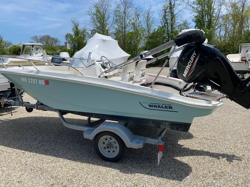 Slide: The Image of 2022 Boston Whaler 130 Super Sport boat on trailer, parked outdoors. - 3