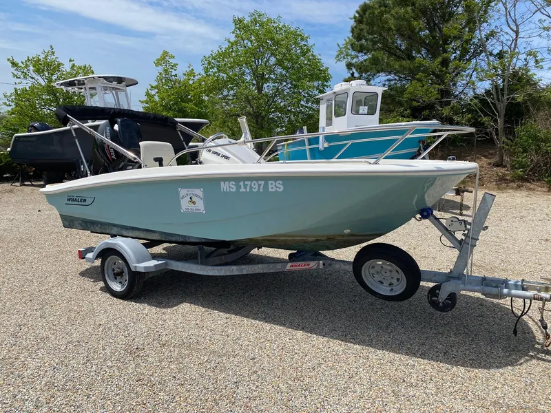 Slide: The Image of 2022 Boston Whaler 130 Super Sport boat on trailer, parked outdoors. - 5