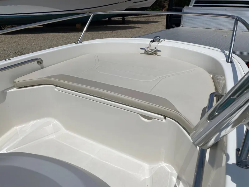 Slide: The Image of 2022 Boston Whaler 130 Super Sport boat interior with cushioned seating. - 6