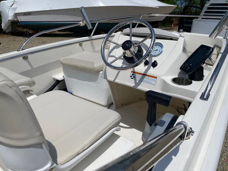 Slide: The Image of 2022 Boston Whaler 130 Super Sport boat interior with steering wheel and seating. - 7