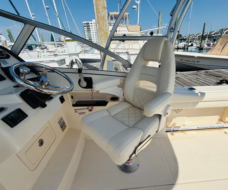 Slide: The Image of 2018 Grady-White Freedom 235 boat cockpit with steering wheel and captain's chair. - 19