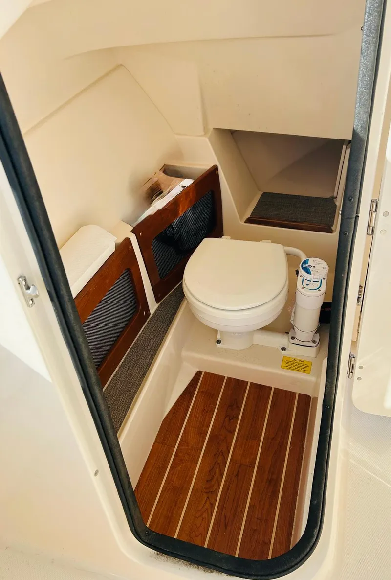 Slide: The Image of 2018 Grady-White Freedom 235 boat interior with compact marine toilet. - 24