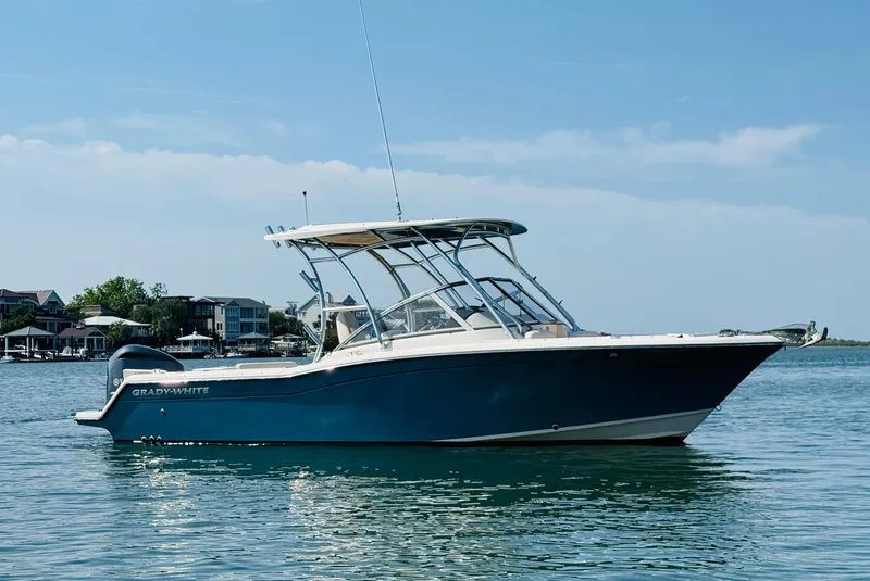 Slide: The Image of 2018 Grady-White Freedom 235 boat on calm water, clear sky background. - 3