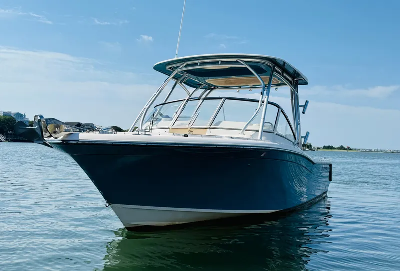 Slide: The Image of 2018 Grady-White Freedom 235 boat on calm water under clear blue sky. - 6