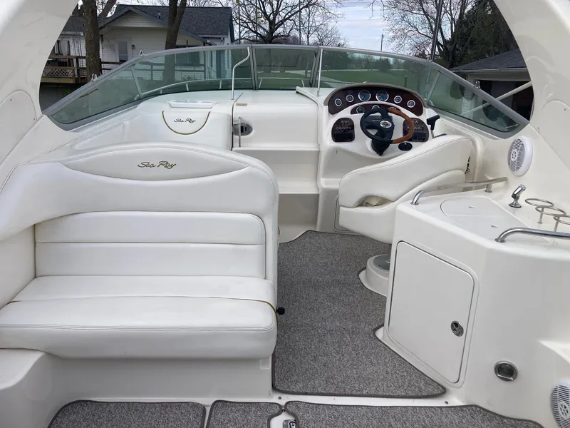 Slide: The Image of 2003 Sea Ray 280 Sundancer boat interior with white seating and helm. - 1