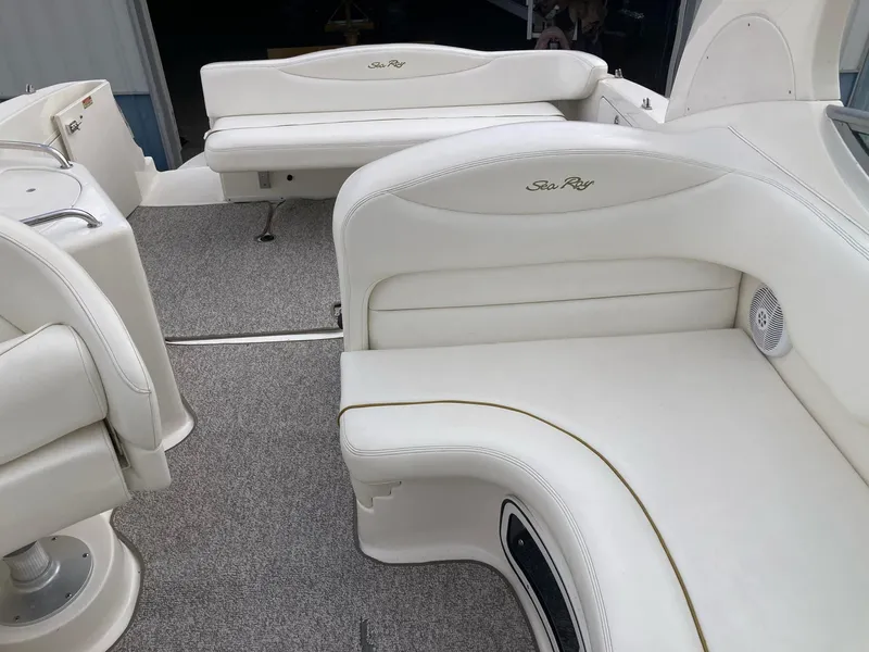 Slide: The Image of 2003 Sea Ray 280 Sundancer boat interior with white seating and carpeted floor. - 12
