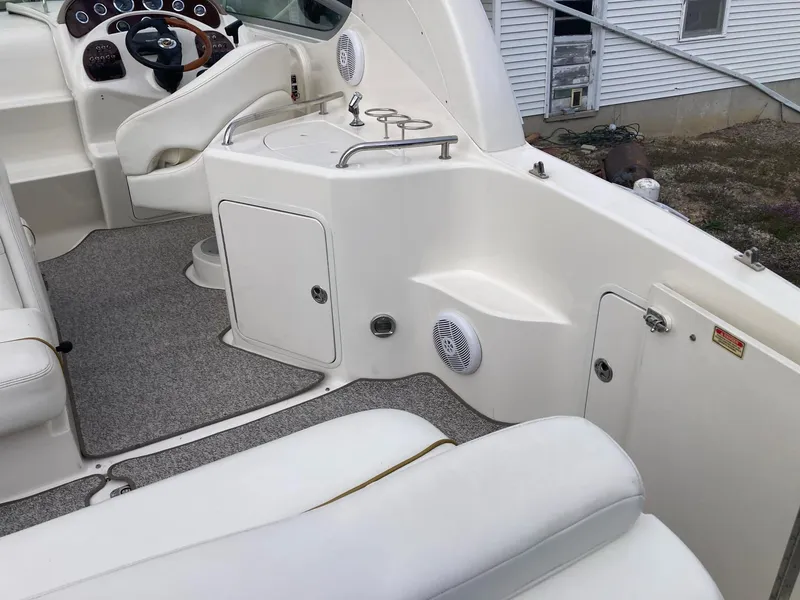 Slide: The Image of 2003 Sea Ray 280 Sundancer boat interior with white seating and control panel. - 13