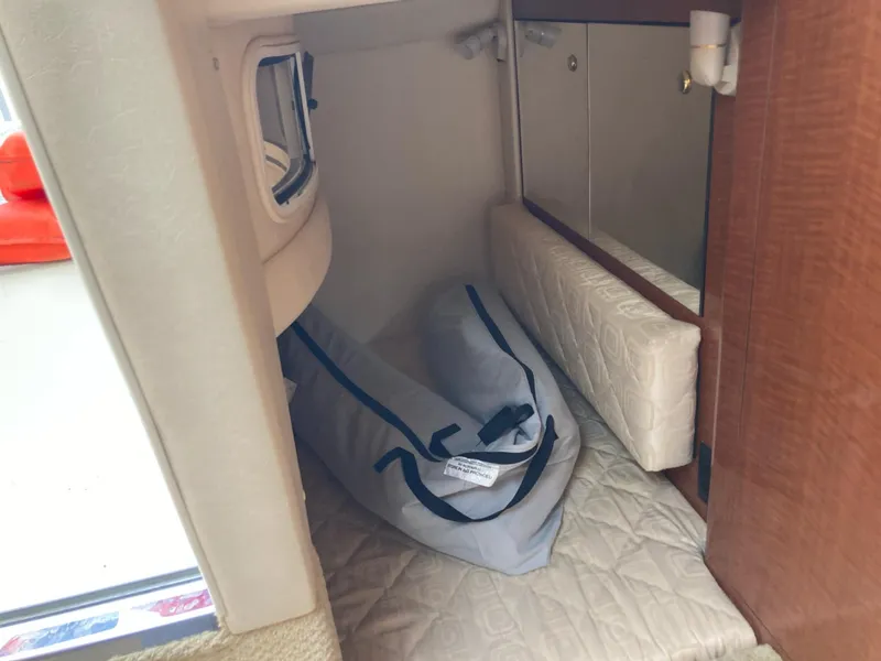 Slide: The Image of 2003 Sea Ray 280 Sundancer cabin interior with bedding and storage. - 7