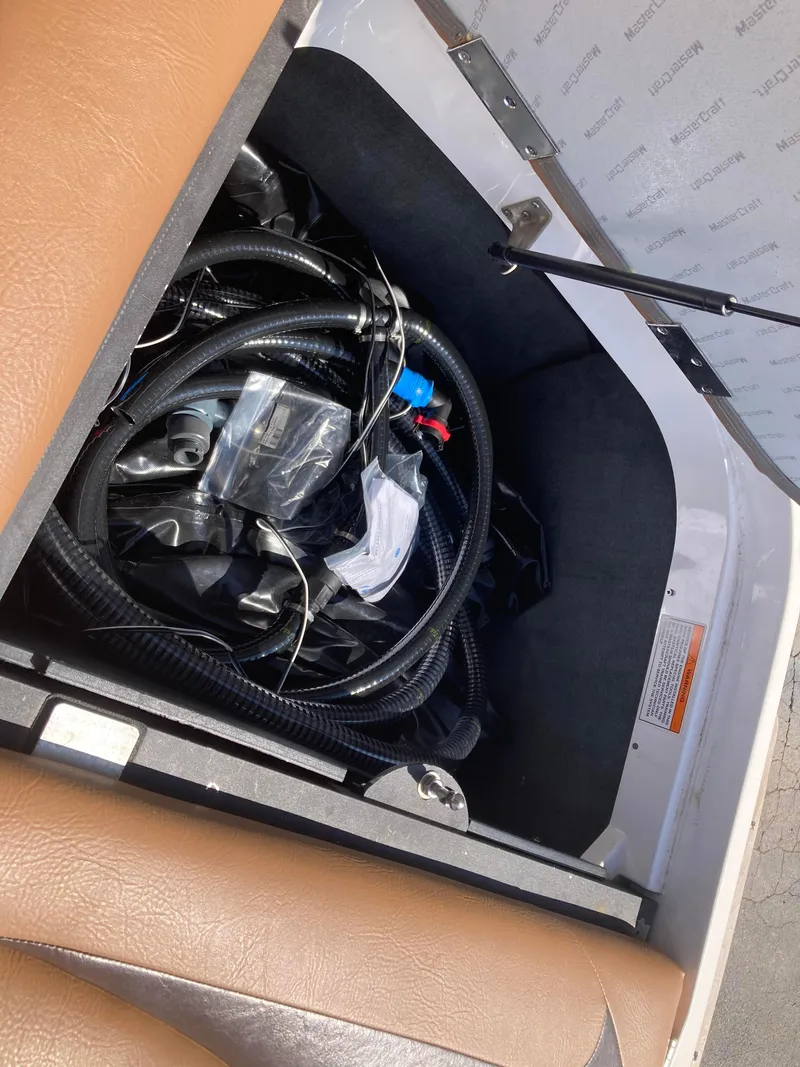 Slide: The Image of Open storage compartment in 2008 MasterCraft MariStar 215 boat, containing hoses and wiring. - 11
