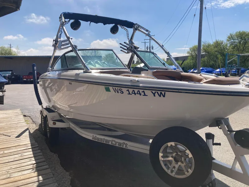 Slide: The Image of 2008 MasterCraft MariStar 215 boat on trailer, parked outdoors under clear sky. - 3