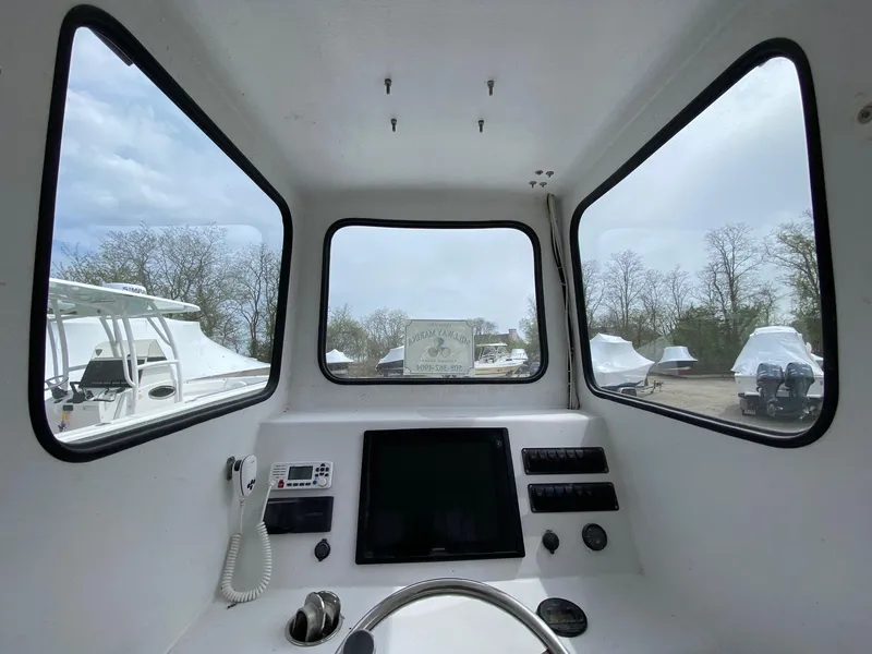 Slide: The Image of Interior view of 1987 SeaCraft 23 CC boat cockpit with steering wheel and controls. - 10