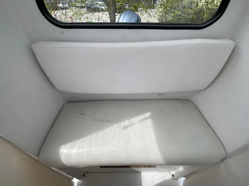 Slide: The Image of Interior view of 1987 SeaCraft 23 CC boat cabin with cushioned seating. - 11