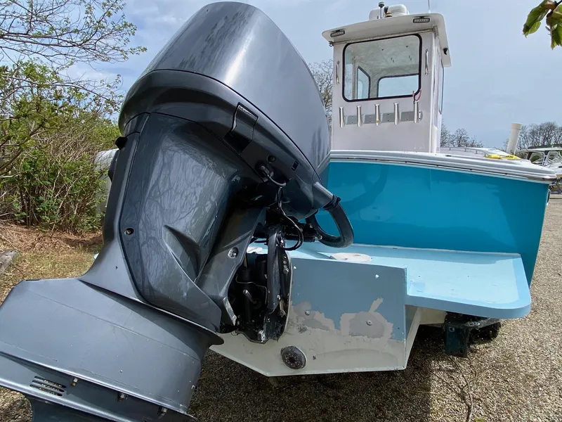 Slide: The Image of 1987 SeaCraft 23 CC boat with outboard motor, parked on gravel. - 4