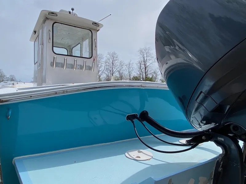 Slide: The Image of 1987 SeaCraft 23 CC boat with blue hull and outboard motor, viewed from the stern. - 5