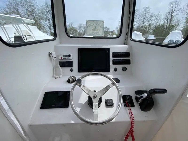 Slide: The Image of 1987 SeaCraft 23 CC boat dashboard with steering wheel and navigation controls. - 9