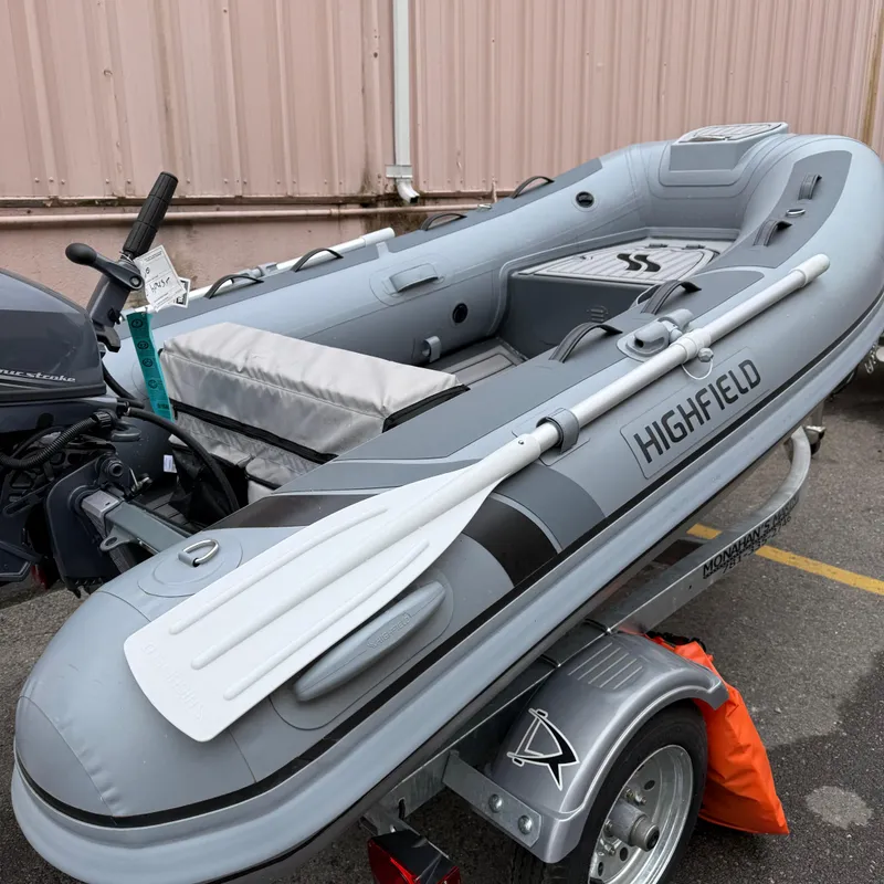 Slide: The Image of 2023 Highfield CL290 inflatable boat on trailer, featuring oars and outboard motor. - 9