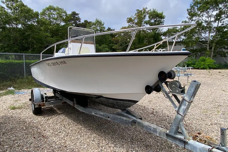 The Image of 1995 Sailfish 19 boat with Yamaha outboard motor on a trailer, parked outdoors. - 0