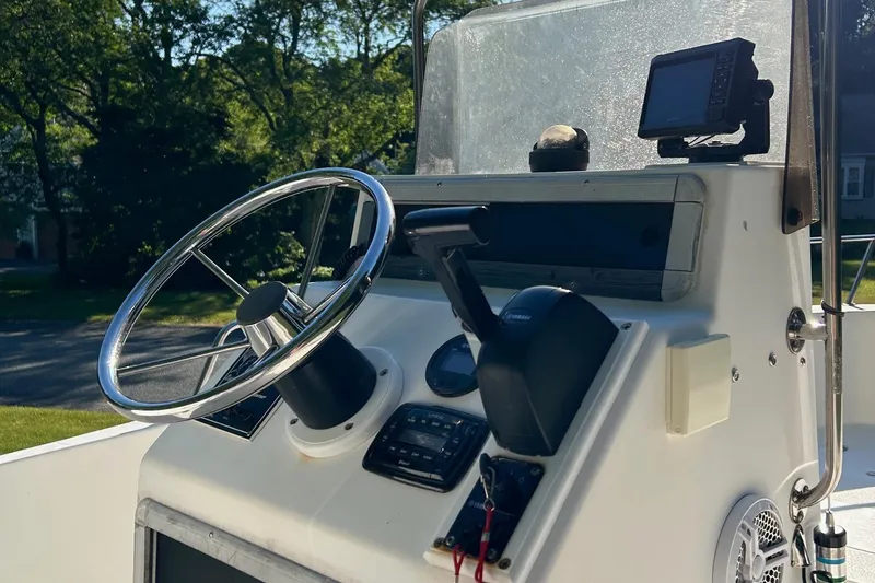 Slide: The Image of 1995 Sailfish 19 boat dashboard with steering wheel and controls. - 10