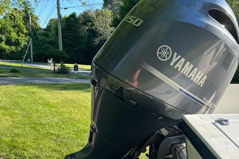 Slide: The Image of Yamaha 150 outboard motor on a 1995 Sailfish 19 boat, parked on grass. - 11